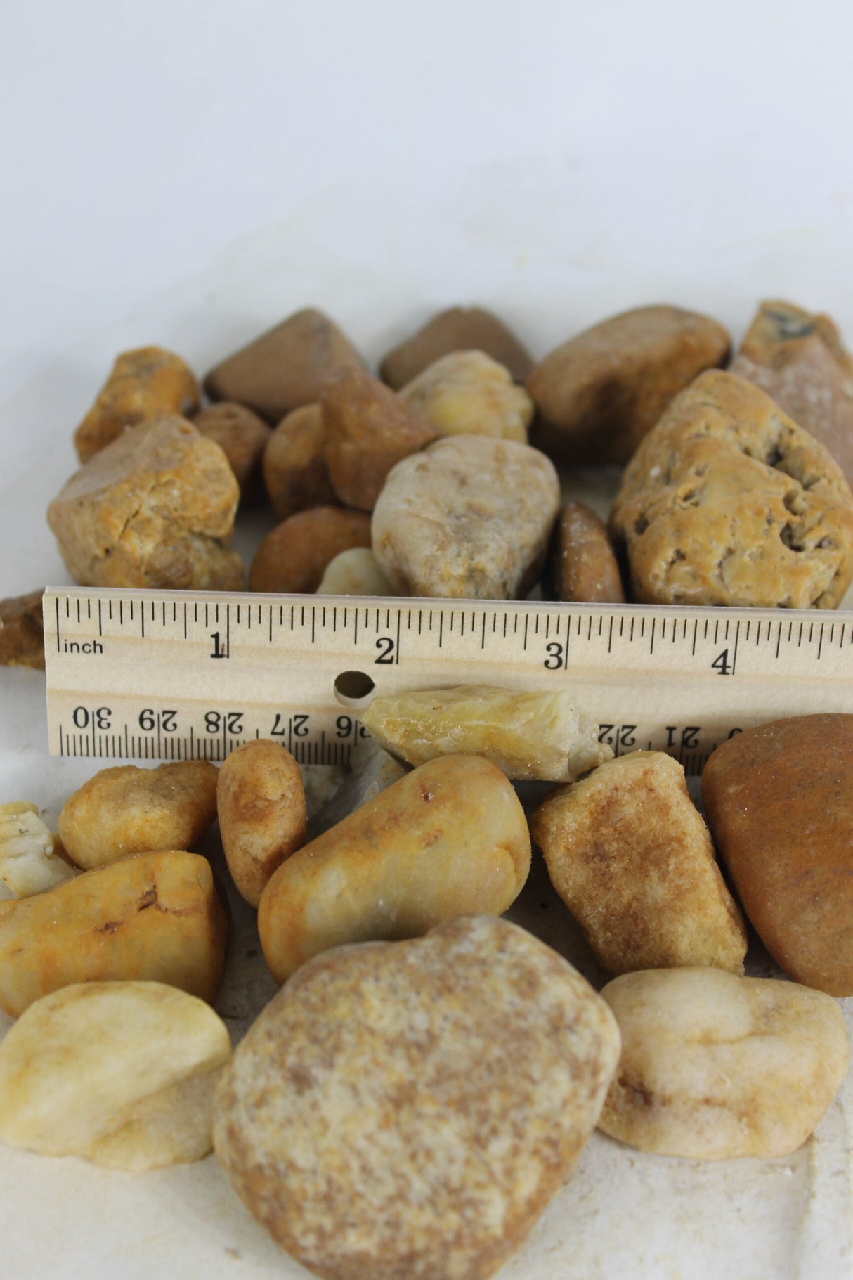 brown river rock compared next to a ruler