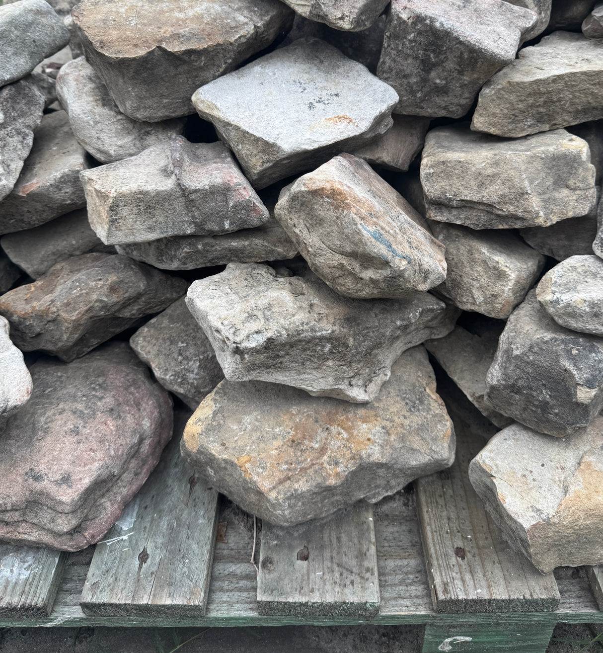 Stack of large gray stones on a wooden pallet