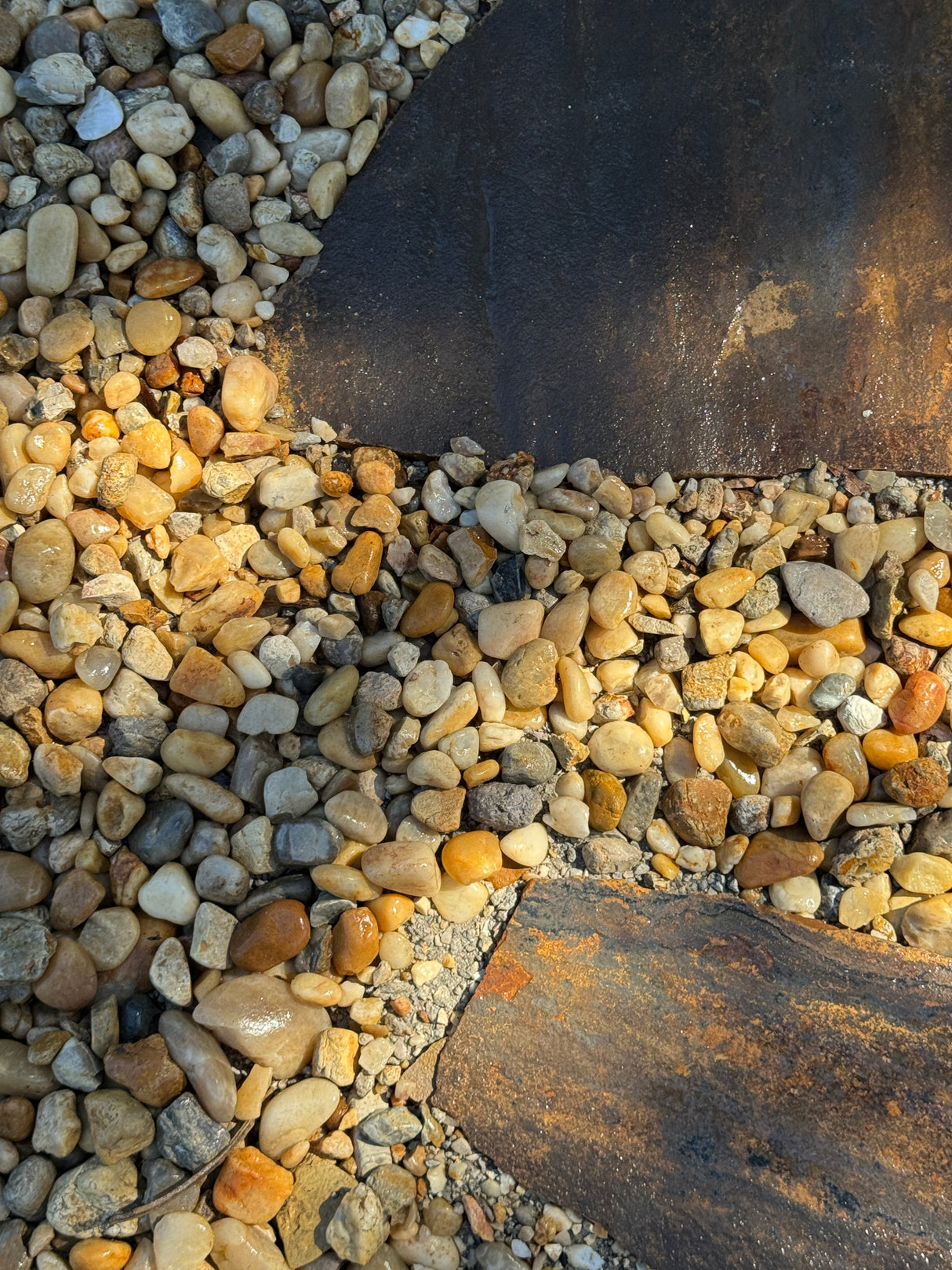 Close-up of pebbles and stones with a focus on texture and color variation.