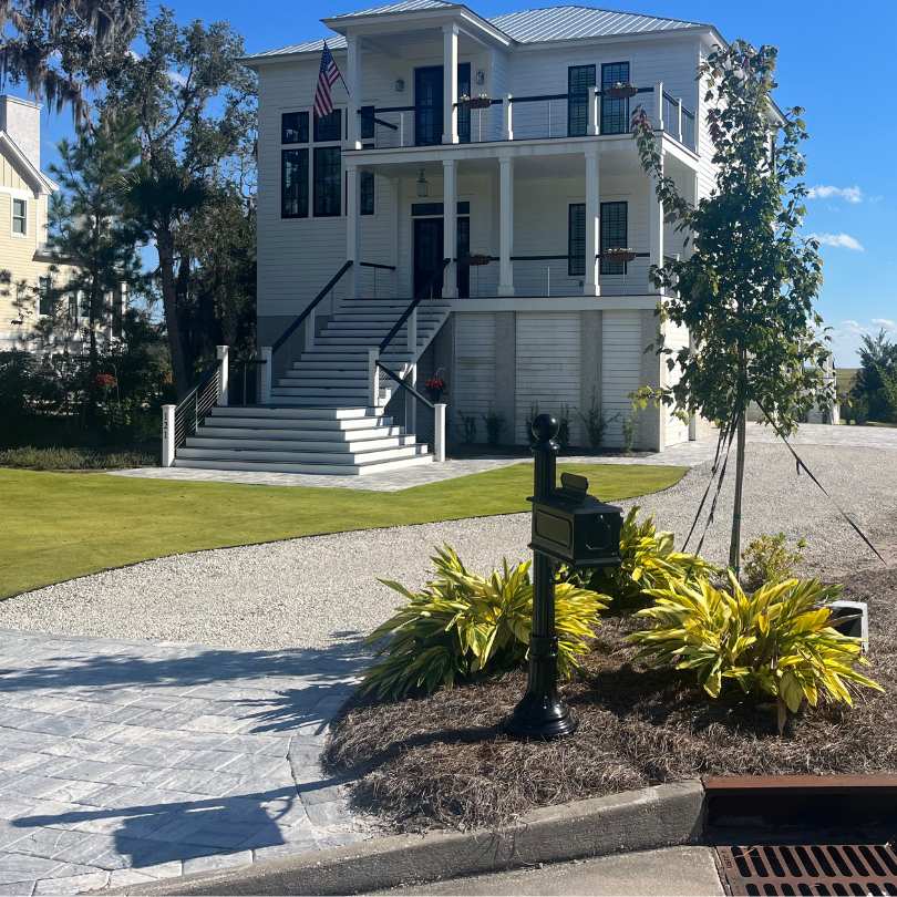 sunny day showing white house and limestone driveway