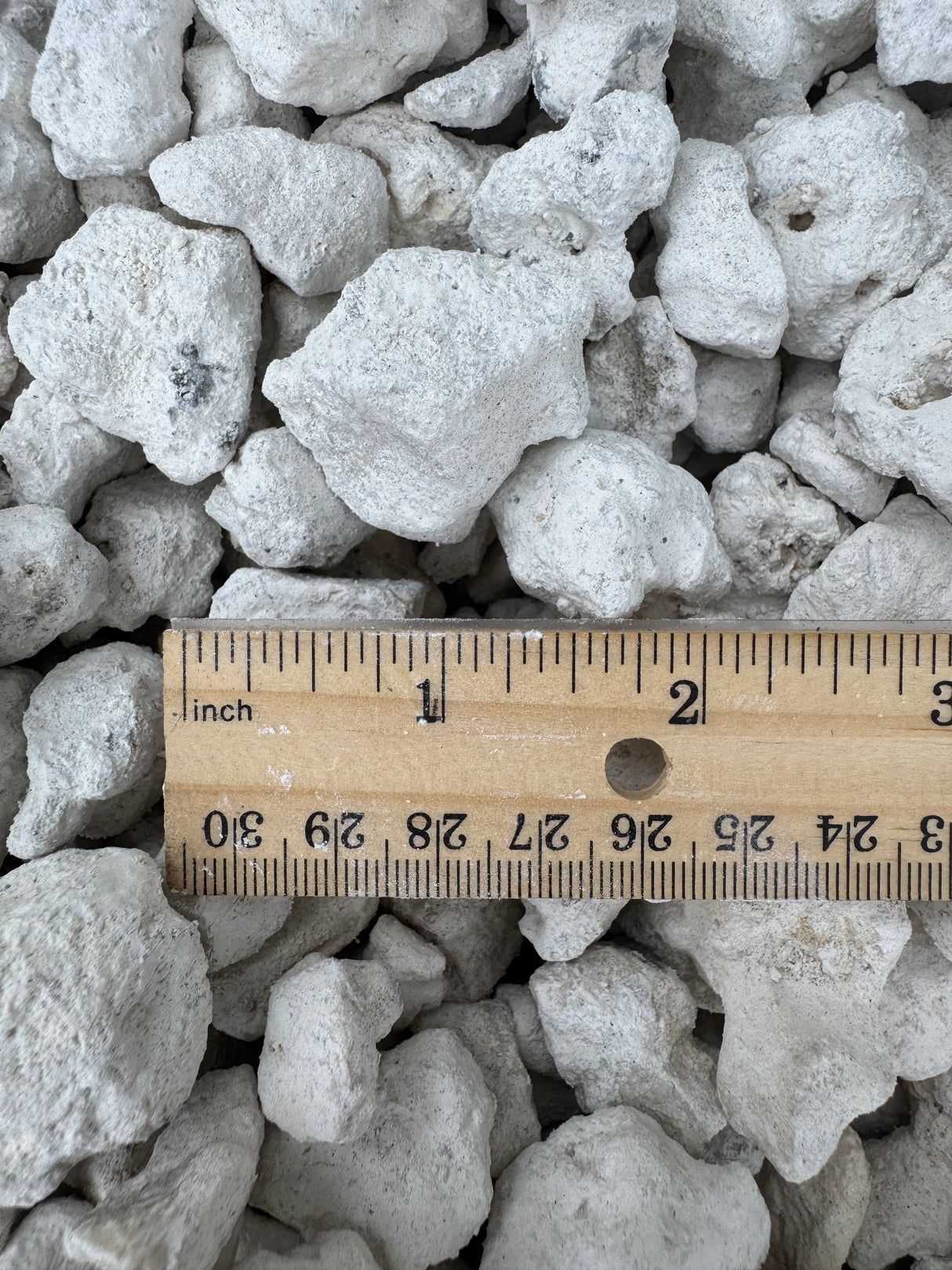 white limestone rocks compared to ruler