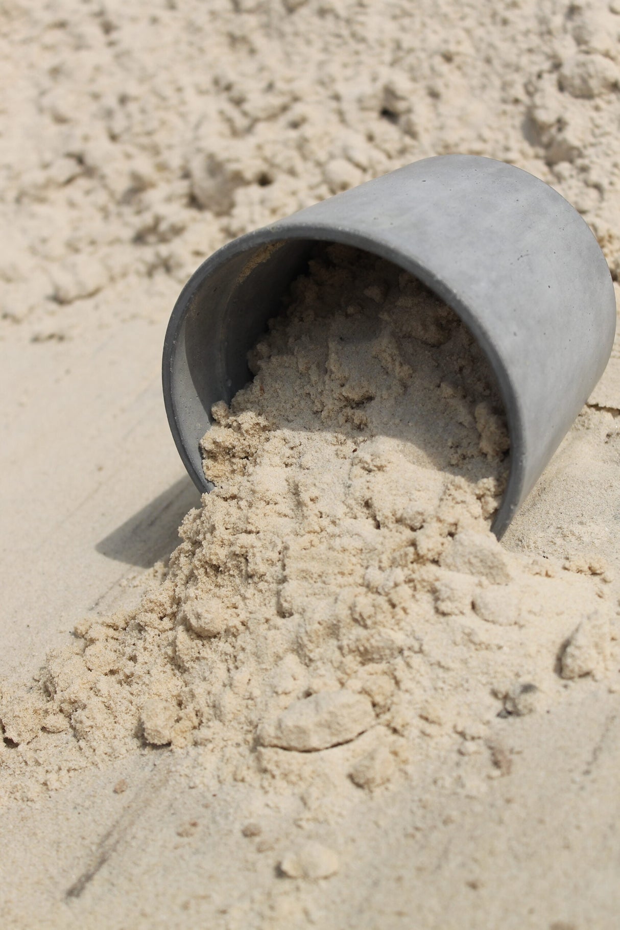 bucket of masonry sand spilled in sand bin