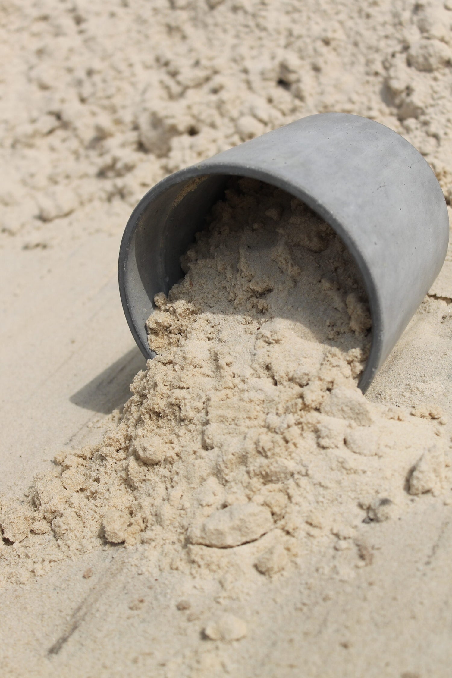 bucket of masonry sand spilled in sand bin