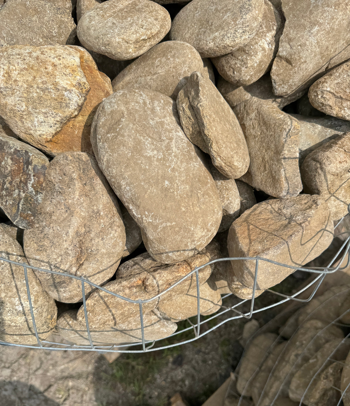 Stack of large stones with a wire basket in the foreground