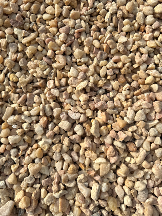 colors of pink, white, and beige make up a pile of white pea gravel