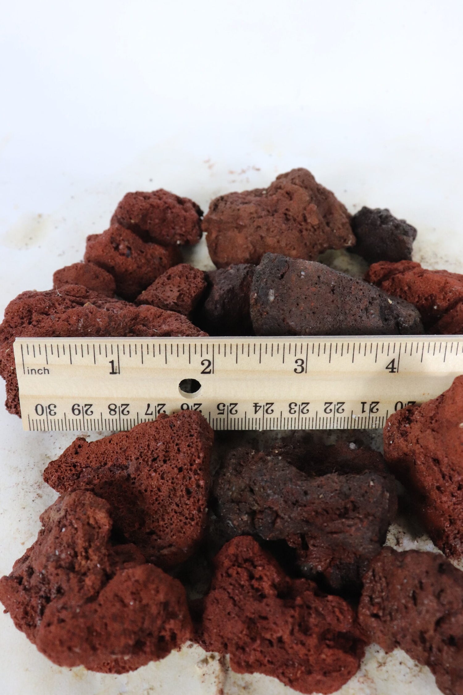 red lava rock compared to ruler measuring around 1 1/2 inches