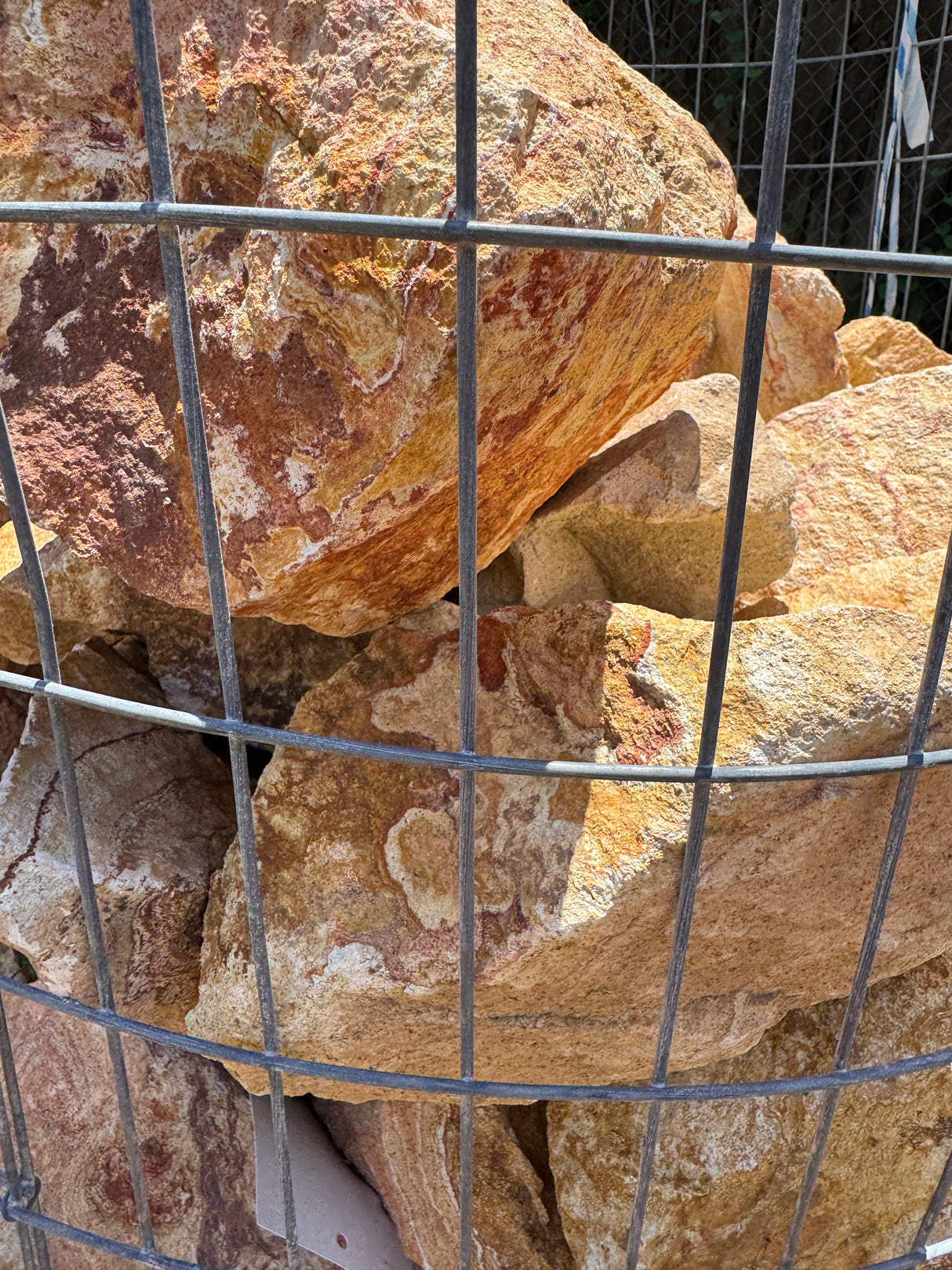 Large multicolored royal XL stones stones behind a wire mesh