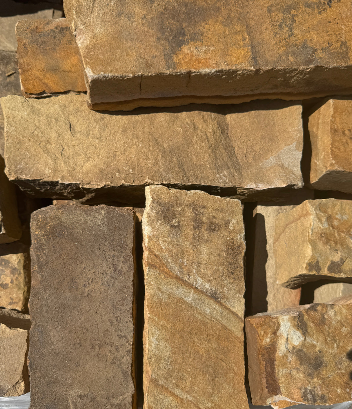 Close-up of stacked stone blocks with varying shades of brown and gray.