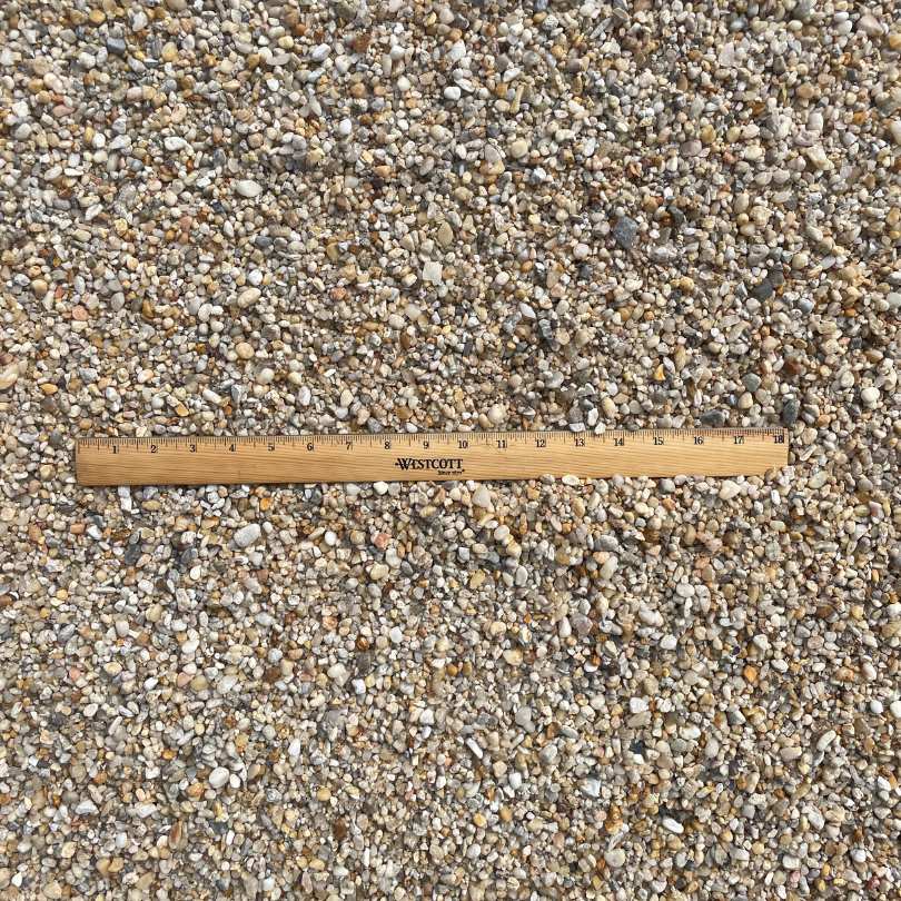ruler in bin of white pea gravel to show size comparison from above