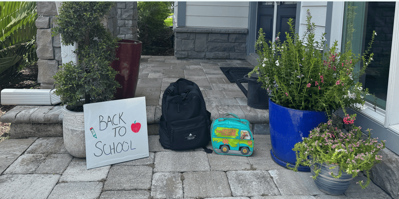 Back to school sign with backpack and toy on a patio
