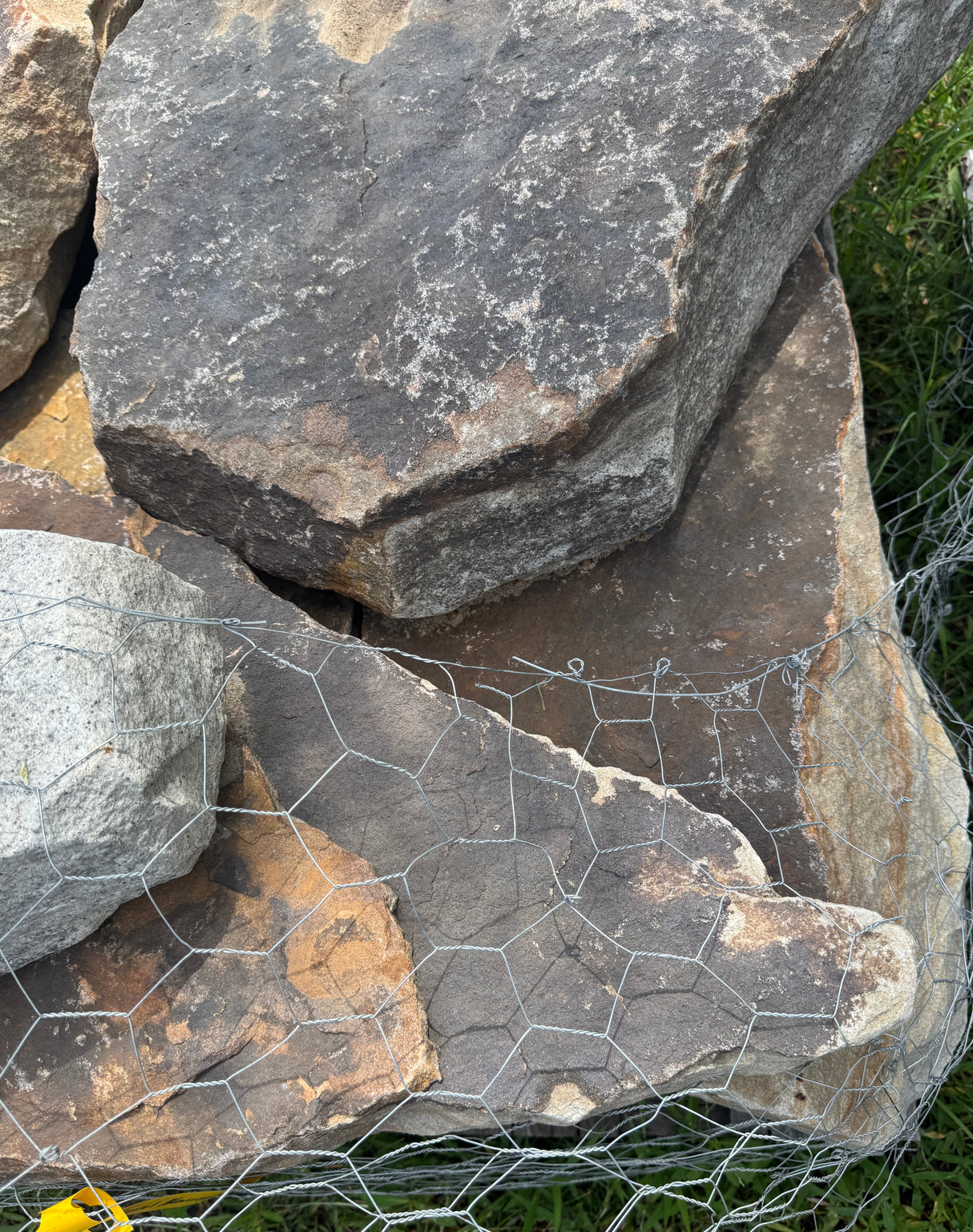 Stack of large stones with a wire mesh on a natural background
