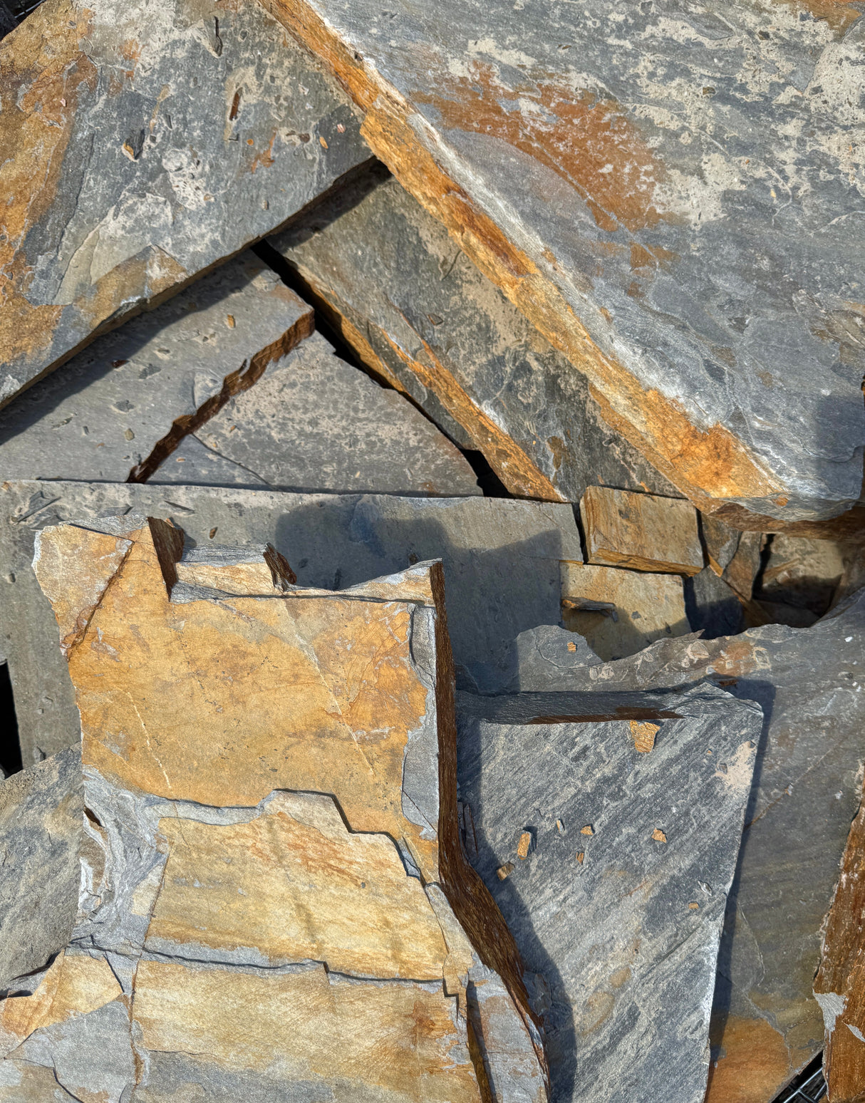Close-up of stacked flagstone slabs with varying shades of gray and brown.