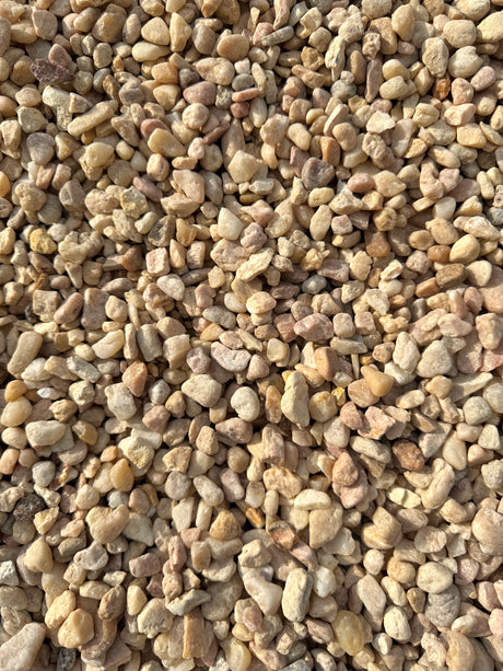 colors of pink, white, and beige make up a pile of white pea gravel