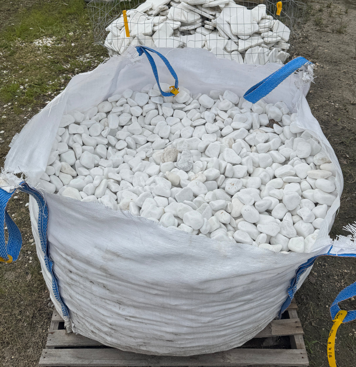Large bag filled with white stones on a wooden pallet