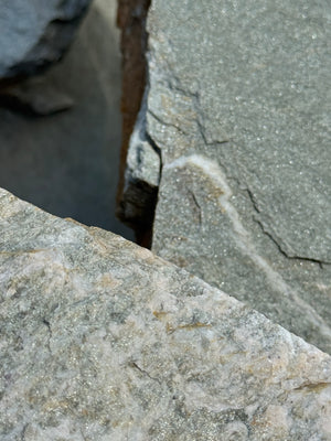 Close-up of textured flagstone surface with shine and natural patterns