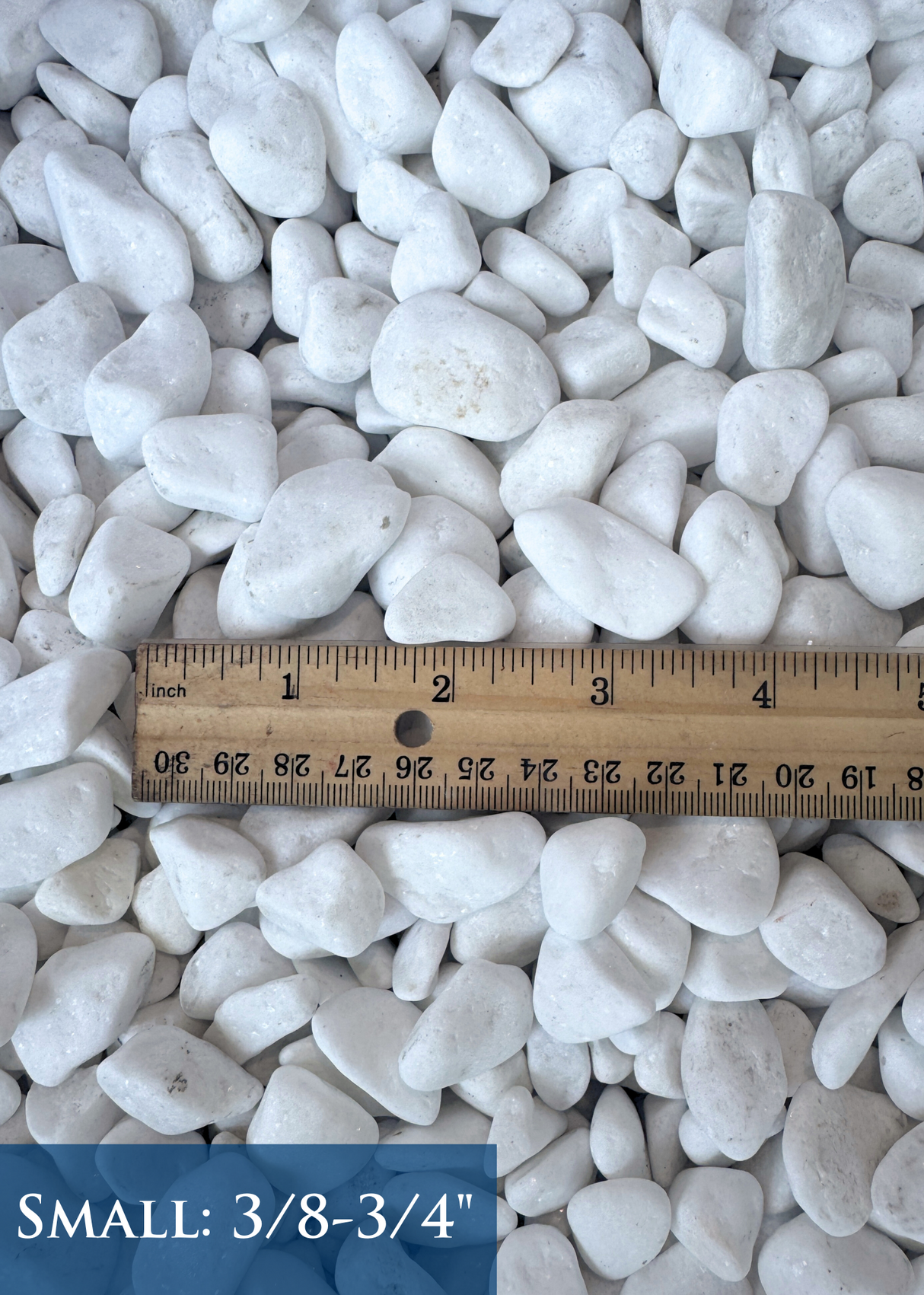 White pebbles with a ruler indicating size on a white background