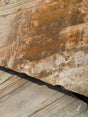 Close-up of a textured stone surface with brown and beige tones.