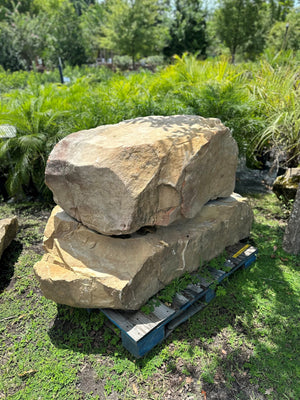 two large Tennessee boulders placed on a pallet in a garden setting
