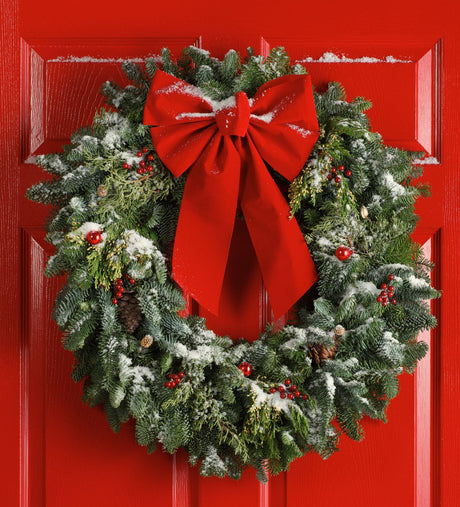 Christmas wreath with a red bow on a red door